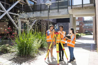a group of 4 student surveying an rea of the university 
